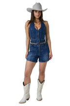 A woman modeling a denim sleeveless vest and matching denim shorts, styled with a light gray cowboy hat and off-white cowboy boots against a white studio background.