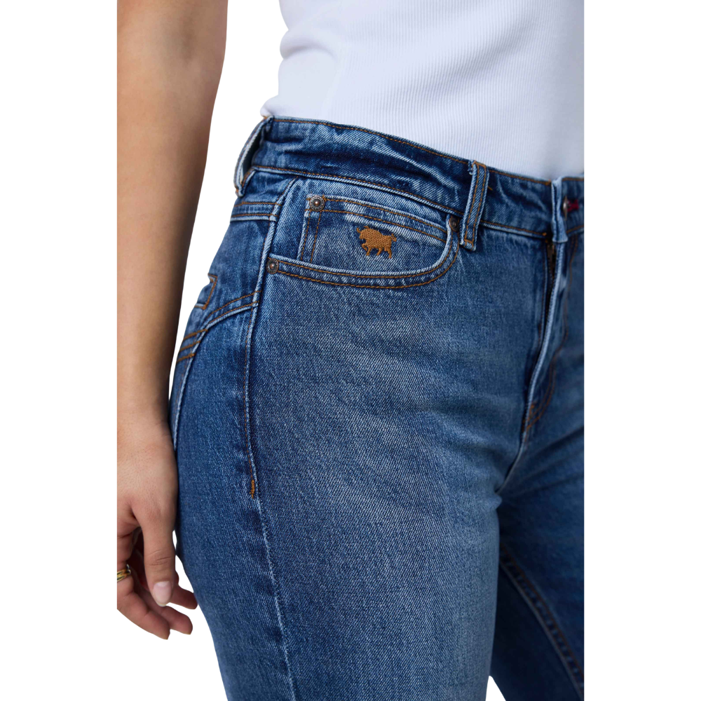 Close-up of a person wearing blue denim jeans with a white ribbed top, showing the front pocket and waistband area against a plain white background.