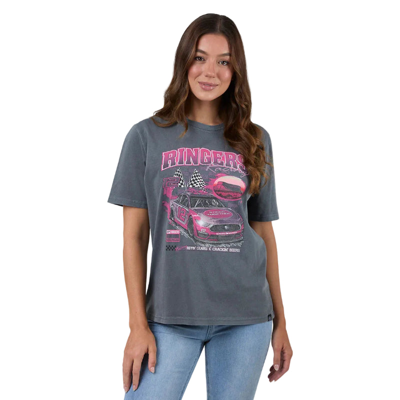 A woman modeling a washed black  graphic t-shirt with a pink and white racing car design and the word 'Ringers' on the front, paired with light blue jeans against a white studio background.