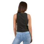 A woman viewed from the back wearing a sleeveless black ribbed tank top and light blue jeans against a plain light background.