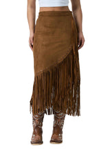 A brown suede fringe midi skirt worn by a model, paired with brown western boots and a white crop top, against a white studio background.