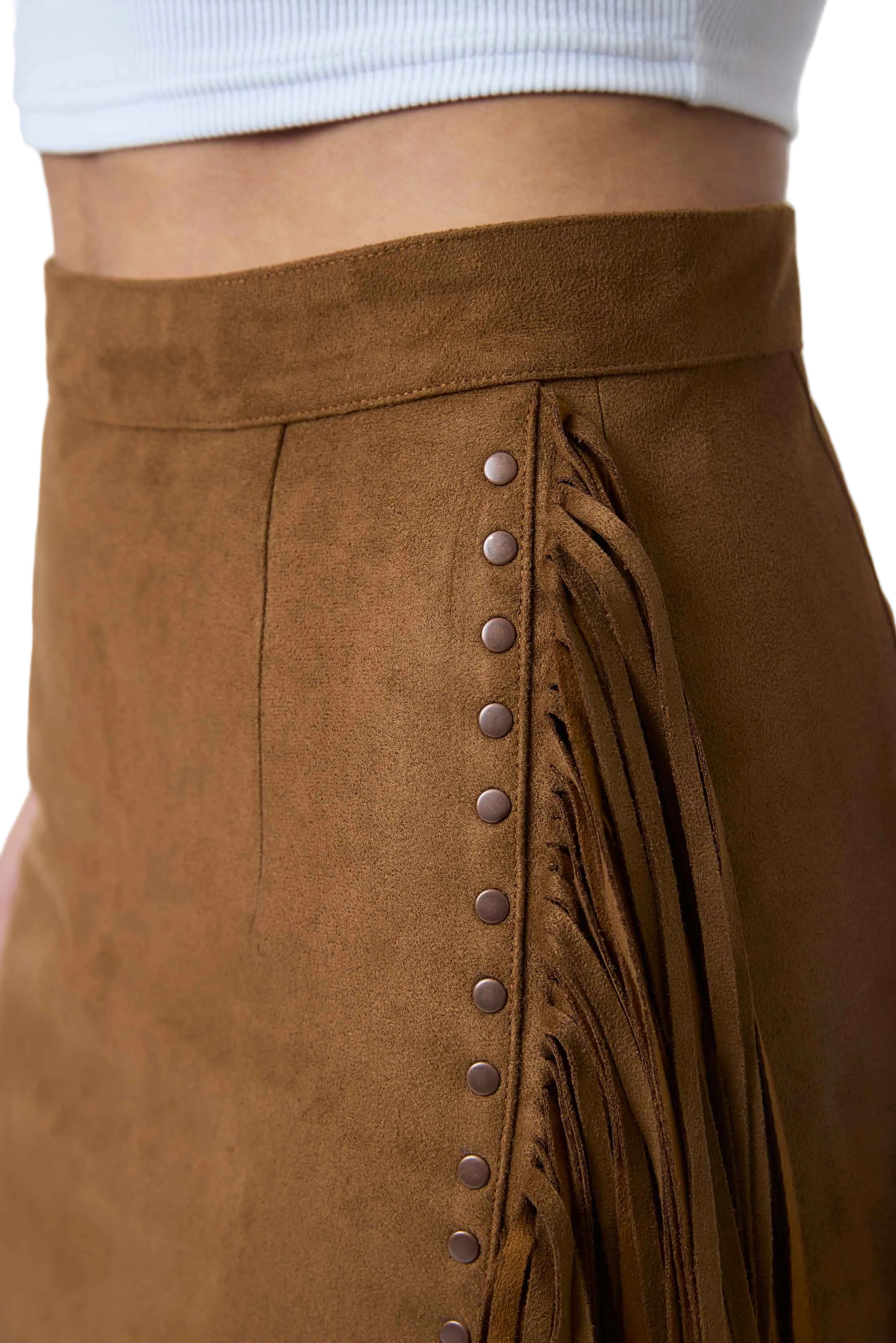 Close-up of a brown suede fringe skirt with a row of metal studs down the side, worn with a white ribbed crop top.