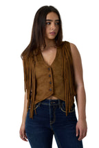 A woman wearing a brown suede fringe vest over a matching brown top, paired with dark blue jeans, photographed against a white studio background.