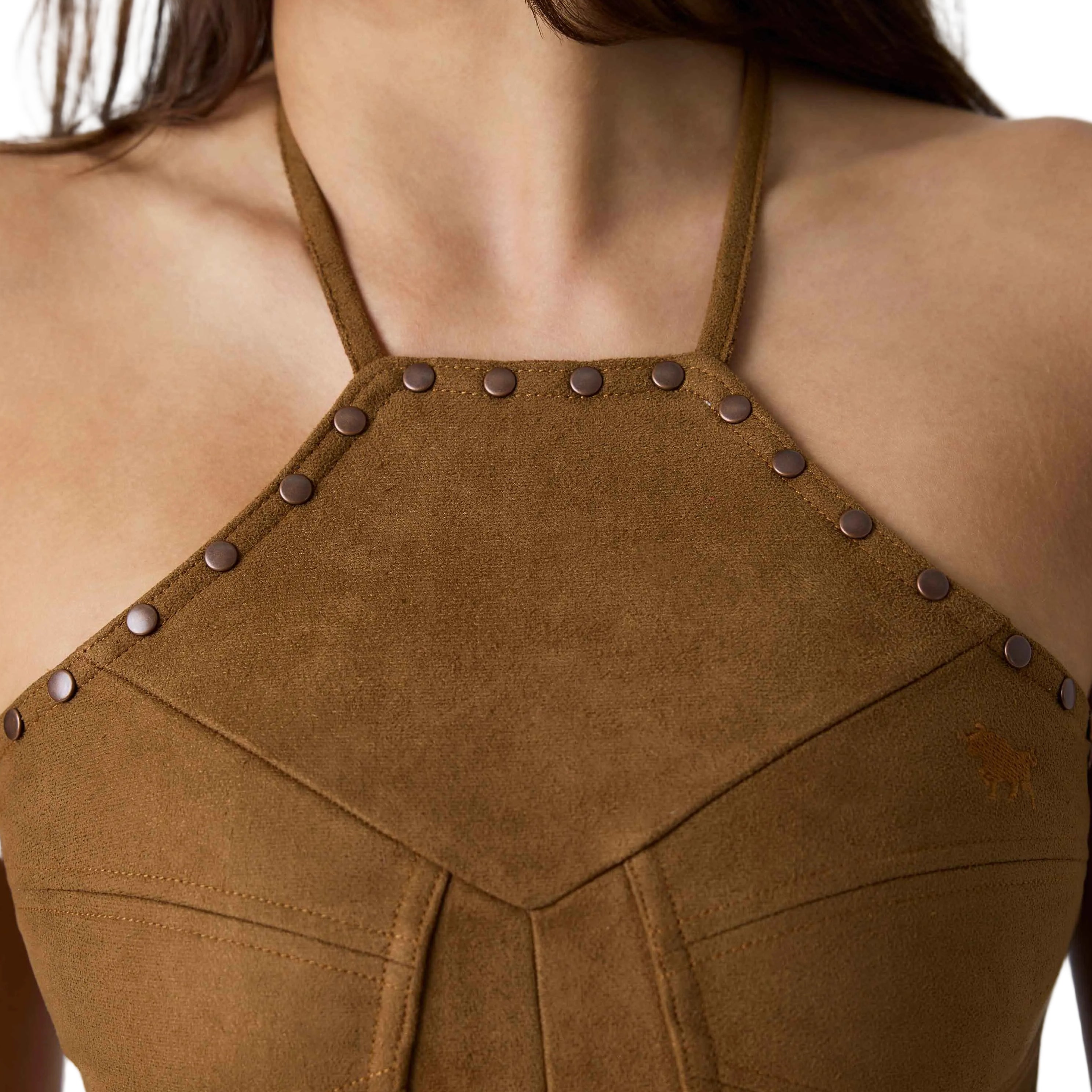 Close-up of a model wearing a brown suede halter top with metal studs and fringe at the hem, against a white background.