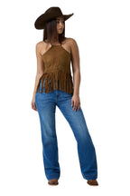 A woman modeling a brown suede halter top with fringe, blue jeans, and a brown cowboy hat against a white studio background.