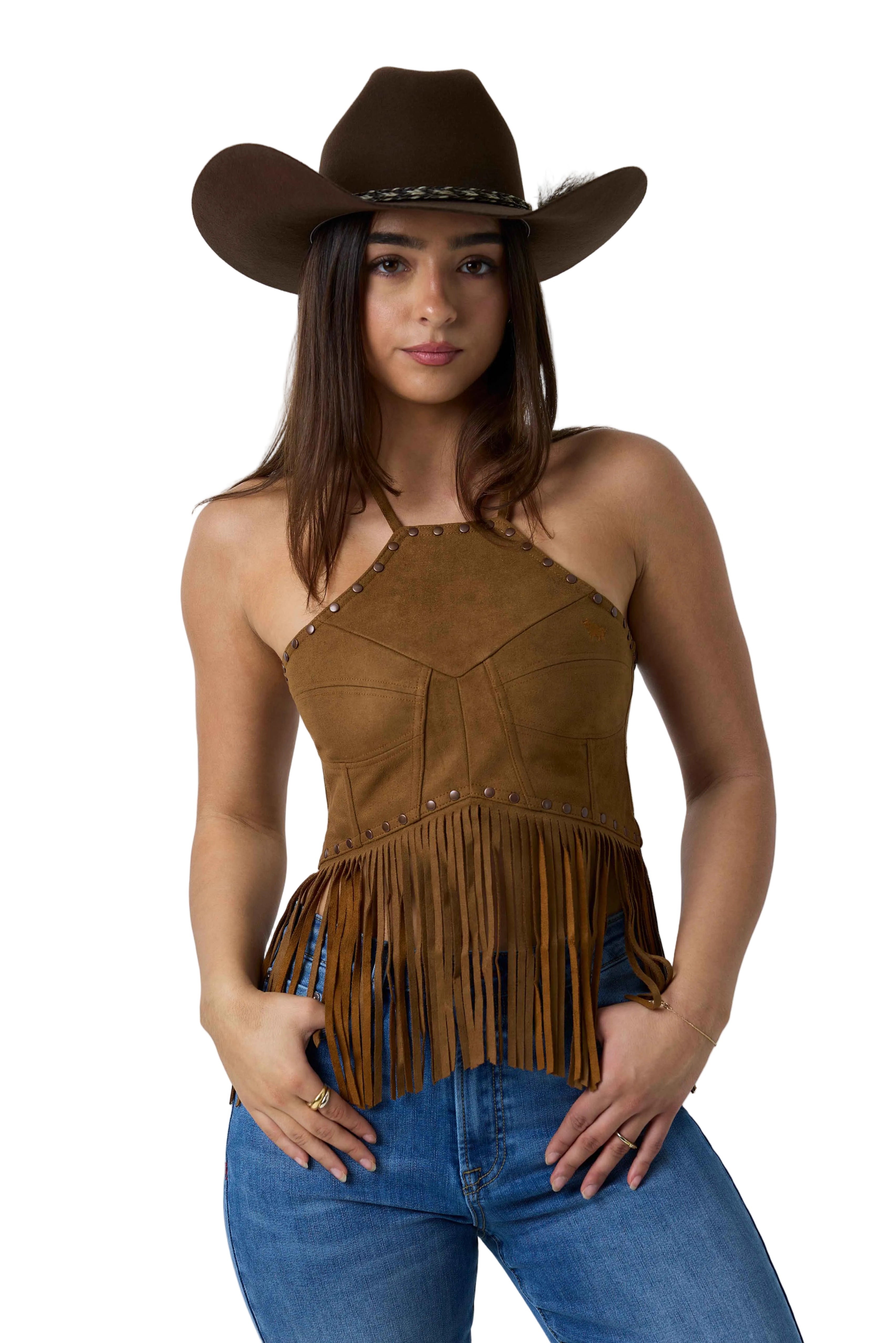 A woman wearing a brown suede halter top with fringe, a matching cowboy hat, and blue jeans, photographed against a white studio background.