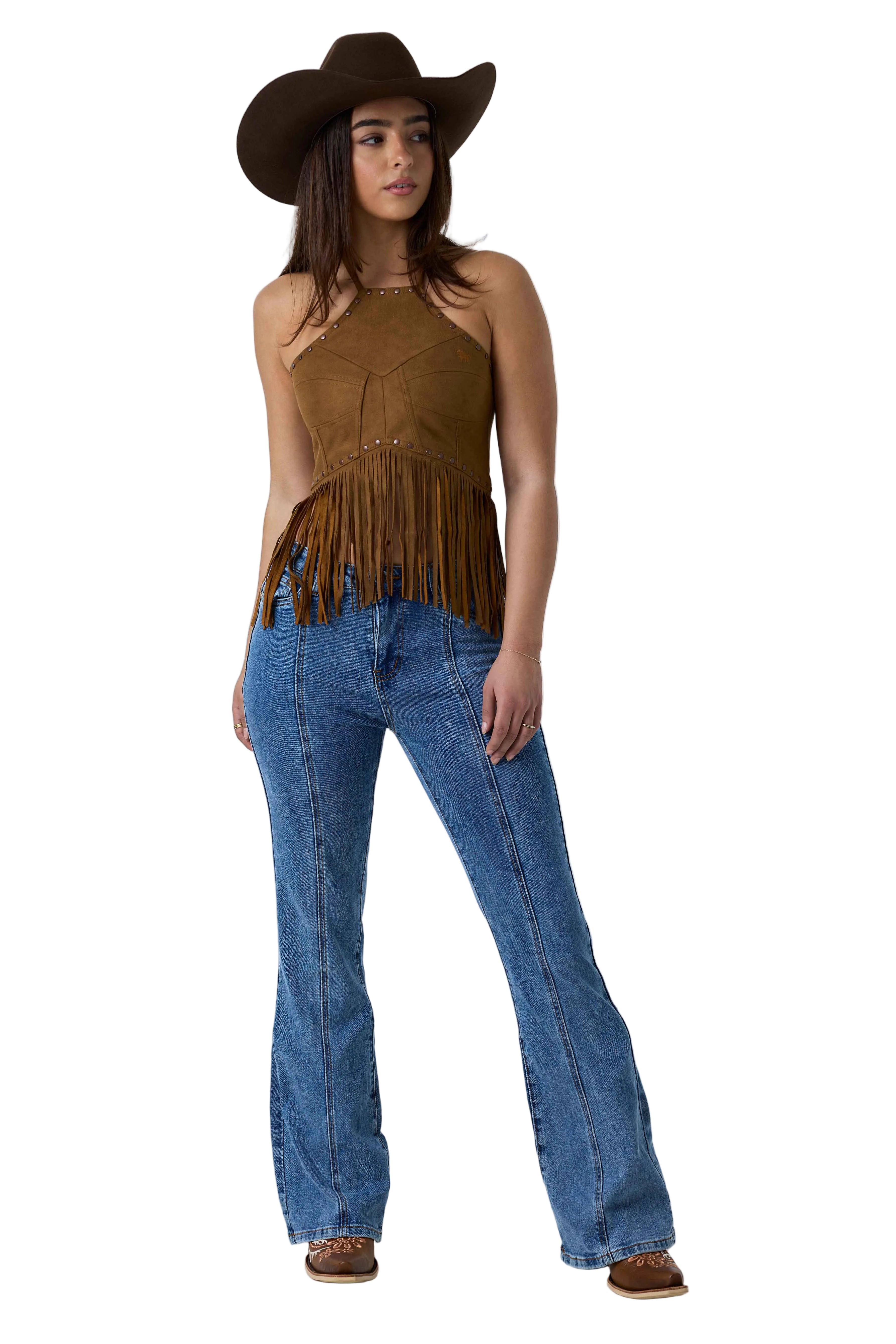 A woman modeling a brown suede halter top with fringe, blue jeans, a brown cowboy hat, and brown boots against a white studio background.