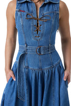 A close-up of a model wearing a blue denim dress with a collar, lace-up front, and a matching belt with a metal ring.