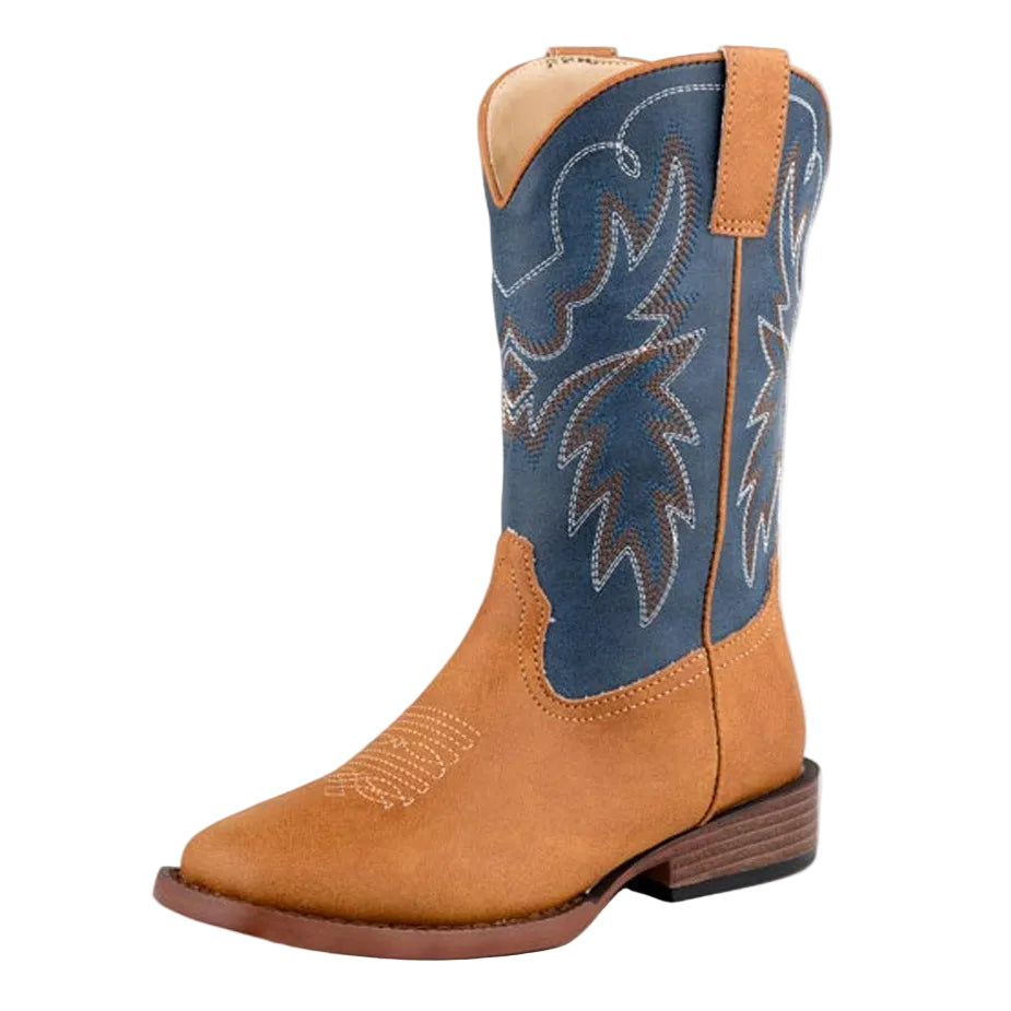 The Roper Big Kids Heritage Western Boot (19900621) by Roper features a tan faux leather foot and heel, navy shaft with white stitching, low wooden heel, and padded insole, shown against a white background.