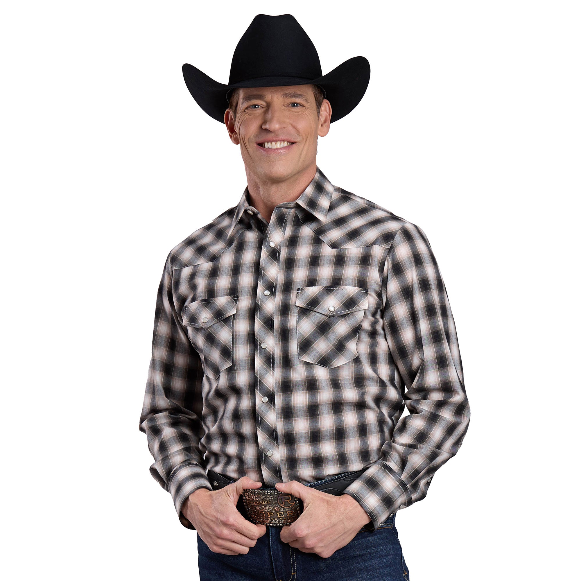 A smiling man wears a black cowboy hat, blue jeans, and the Roper Men's Karman Classic 55/45 Collection L/S Shirt (01101026) Plaid Black, holding a large belt buckle and standing against a white background.