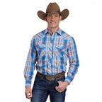 A smiling man wears the Roper Mens Karman Classic 55/45 Collection L/S Shirt (01101220) Plaid Blue, jeans, a brown cowboy hat, and a large belt buckle as he stands against a white background with one hand on his hip.