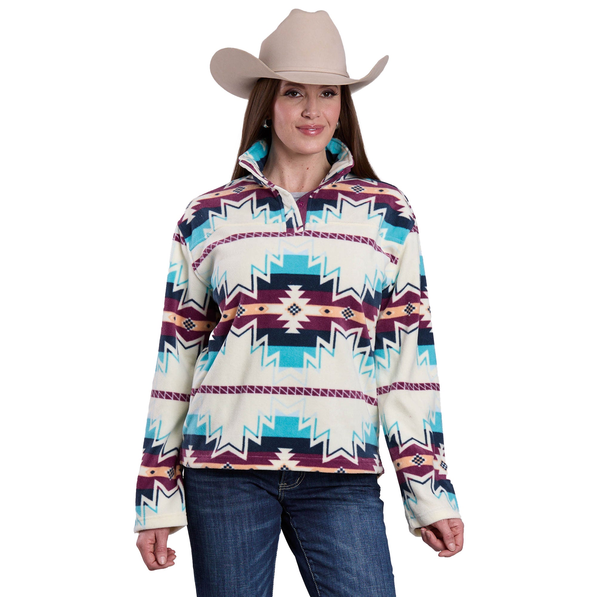 A woman in a beige cowboy hat, blue jeans, and the Roper Womens L/S Pullover (98250706) Multi—featuring teal, burgundy, and white geometric designs—stands smiling at the camera.