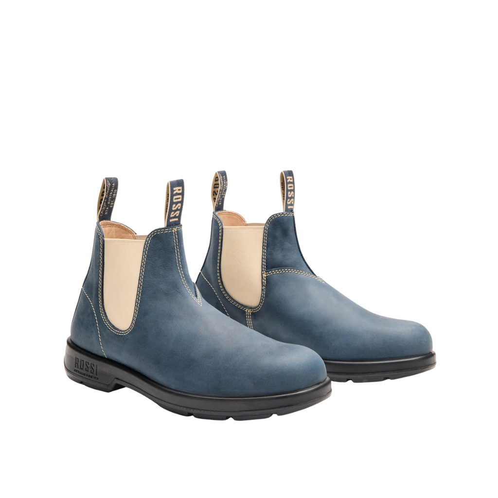 The Rossi Boots Unisex Spinifex Elastic Sided Boots (404 STM) Storm feature blue yak leather, beige elastic side panels, black anti-slip soles, and "Rossi" pull tabs at the heel and tongue.