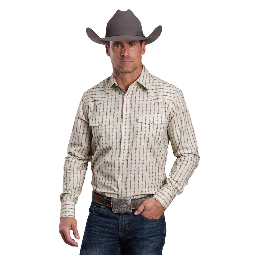A man wears a Stetson Mens Collection L/S Shirt (01476012) in white, blue jeans, a large belt buckle, and a gray Stetson cowboy hat, standing forward with one hand on his belt.