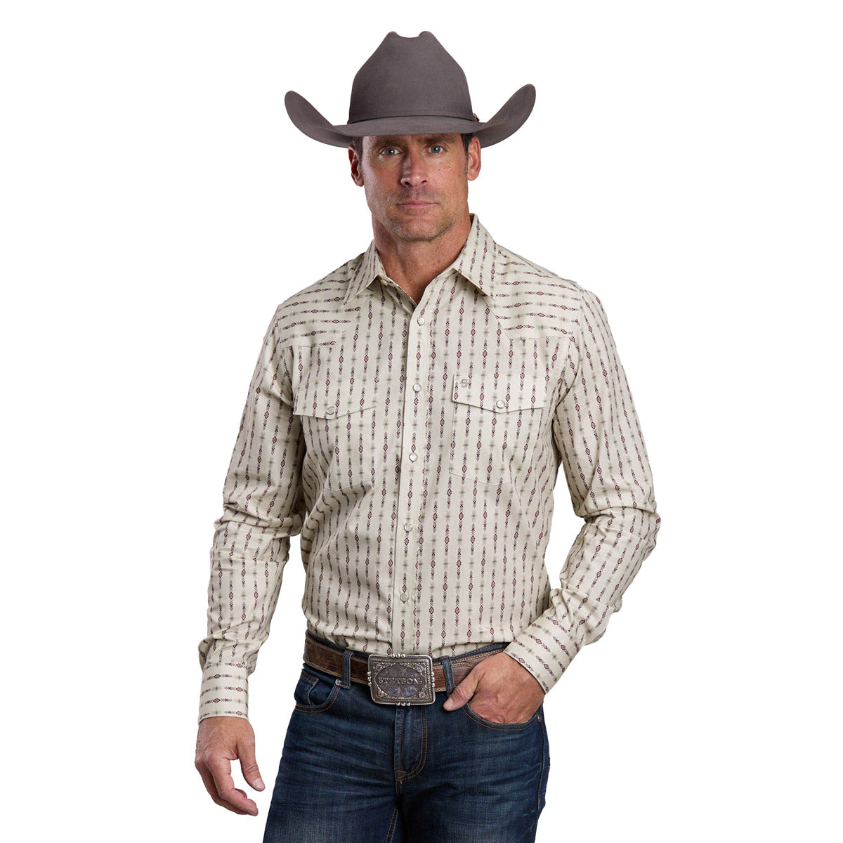 A man wears a Stetson Mens Collection L/S Shirt (01476012) in white, blue jeans, a large belt buckle, and a gray Stetson cowboy hat, standing forward with one hand on his belt.