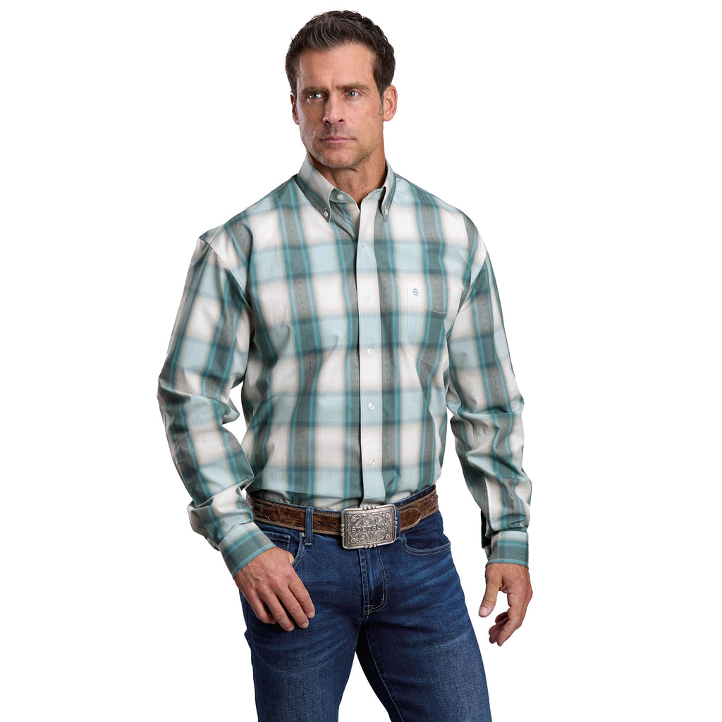 A man wearing a Stetson Mens Collection L/S Shirt (01579003) Plaid Blue stands with one hand in his pocket, paired with blue jeans and a large belt buckle, against a plain white background.