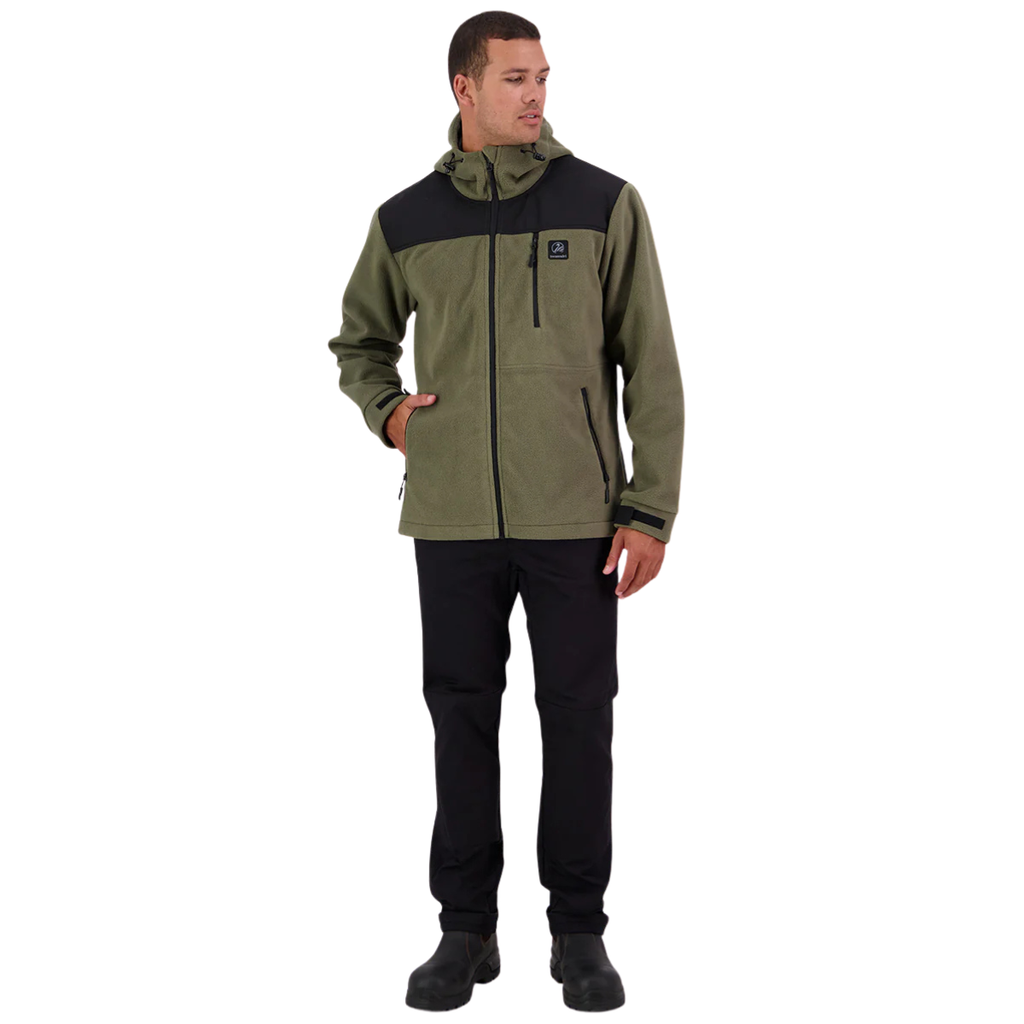 A man stands against a white background, wearing the Swanndri Men's High Rock Stormshield Jacket (SW2562070M) in Forest, an olive green weatherproof fleece with black yoke and lower back