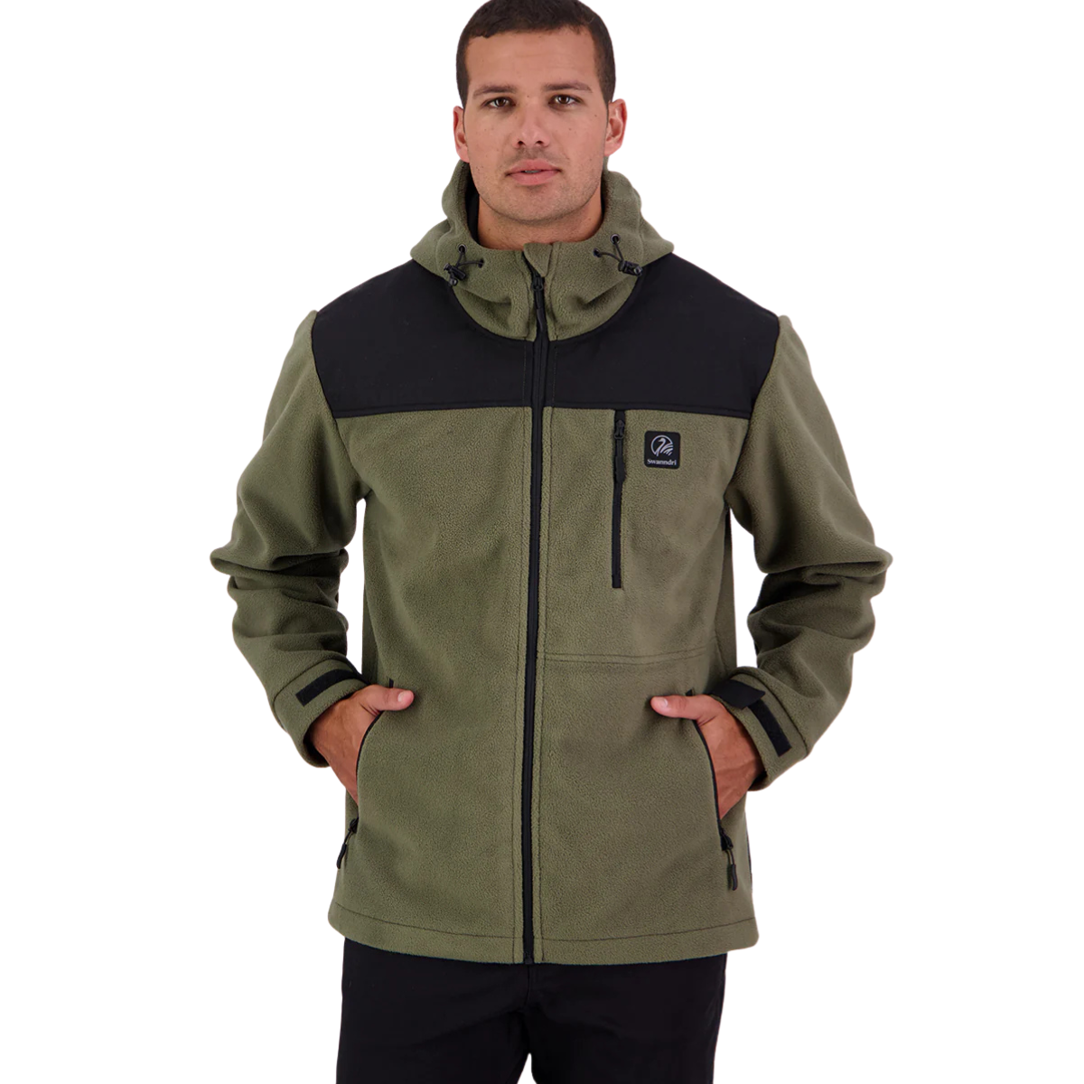 A man stands with hands in his pockets against a white background, wearing the Swanndri Mens High Rock Stormshield Jacket (SW2562070M) in Forest, an olive green weatherproof fleece with black accents on shoulders and chest.
