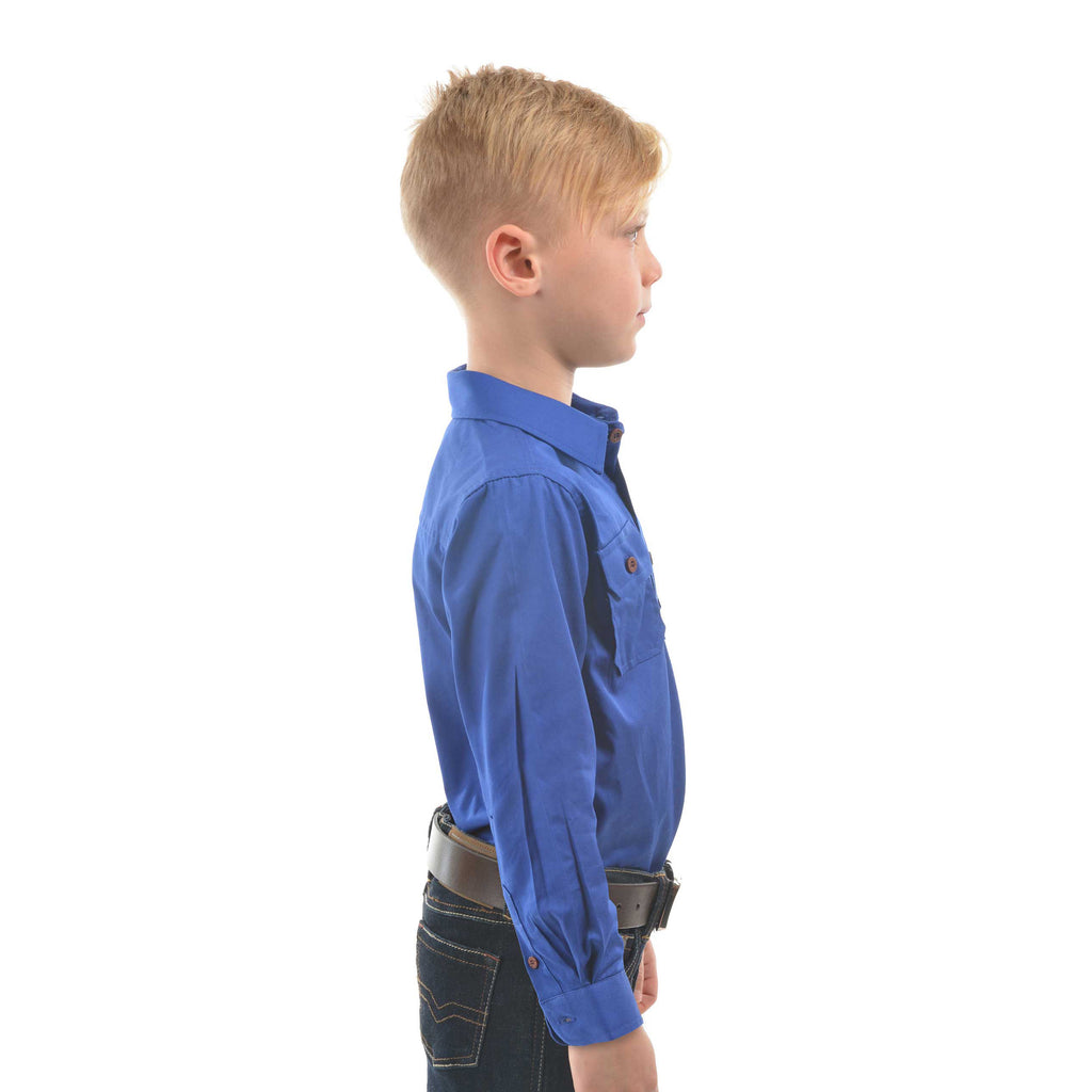 A young boy in profile modelling a cobalt blue Thomas Cook Children's Heavy Drill Half Button Long Sleeve Shirt (TCP7100163) with two chest pockets, paired with dark jeans and a brown belt, on a white background.