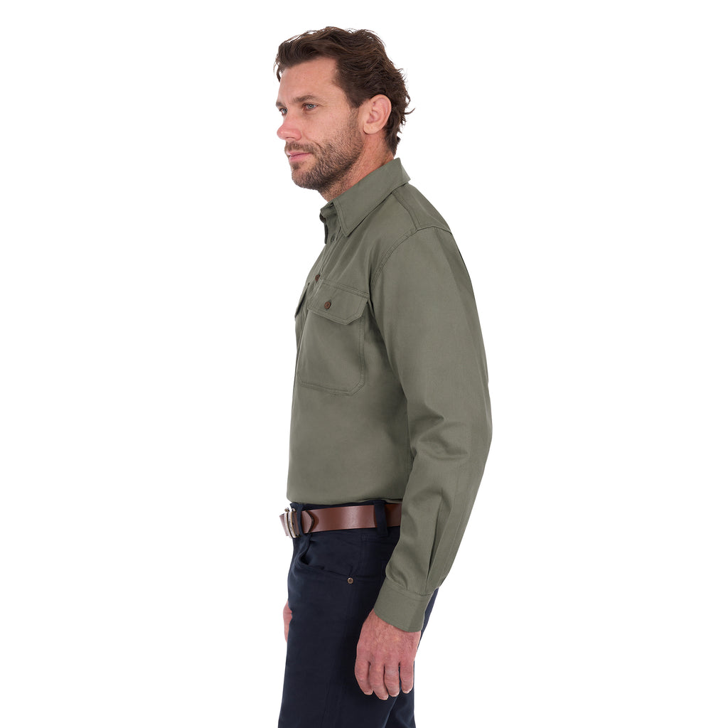A man shown in profile wearing a Thomas Cook Heavy Drill Half Button Long Sleeve Work Shirt (TCP1120163) in military green, paired with dark blue jeans and a brown belt, against a plain white background.