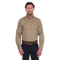 A man modelling a sand coloured Thomas Cook Heavy Drill Half Button L/S Work Shirt (TCP1120163) paired with navy blue pants and a tan belt, on a white background.