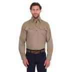 A man modelling a sand coloured Thomas Cook Heavy Drill Half Button L/S Work Shirt (TCP1120163) paired with navy blue pants and a tan belt, on a white background.