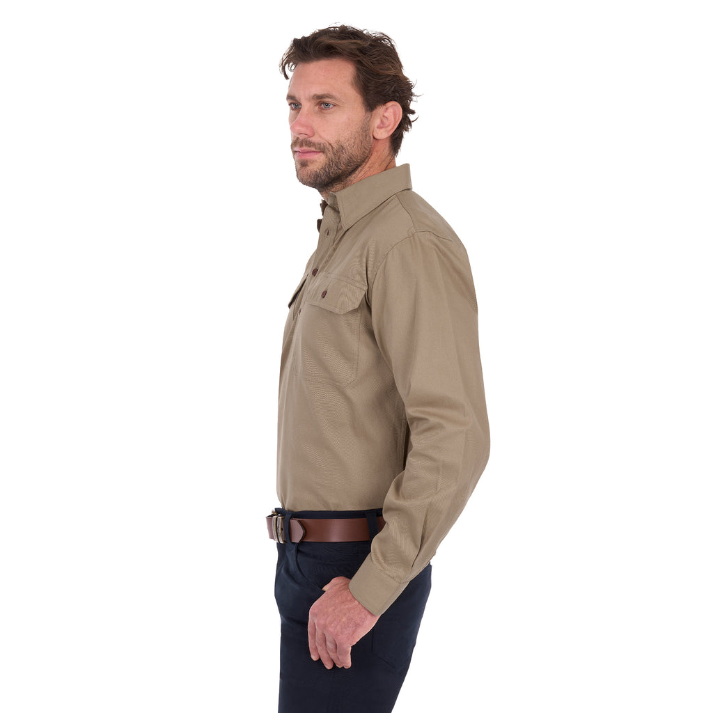 A man modelling a sand coloured Thomas Cook Heavy Drill Half Button L/S Work Shirt (TCP1120163) paired with navy blue pants and a tan belt, on a white background.
