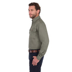 A man in profile modelling a military green Thomas Cook Light Drill Half Button Long Sleeve Work Shirt (TCP1126005) with two chest flap pockets, paired with dark jeans and a brown belt, against a plain white background.