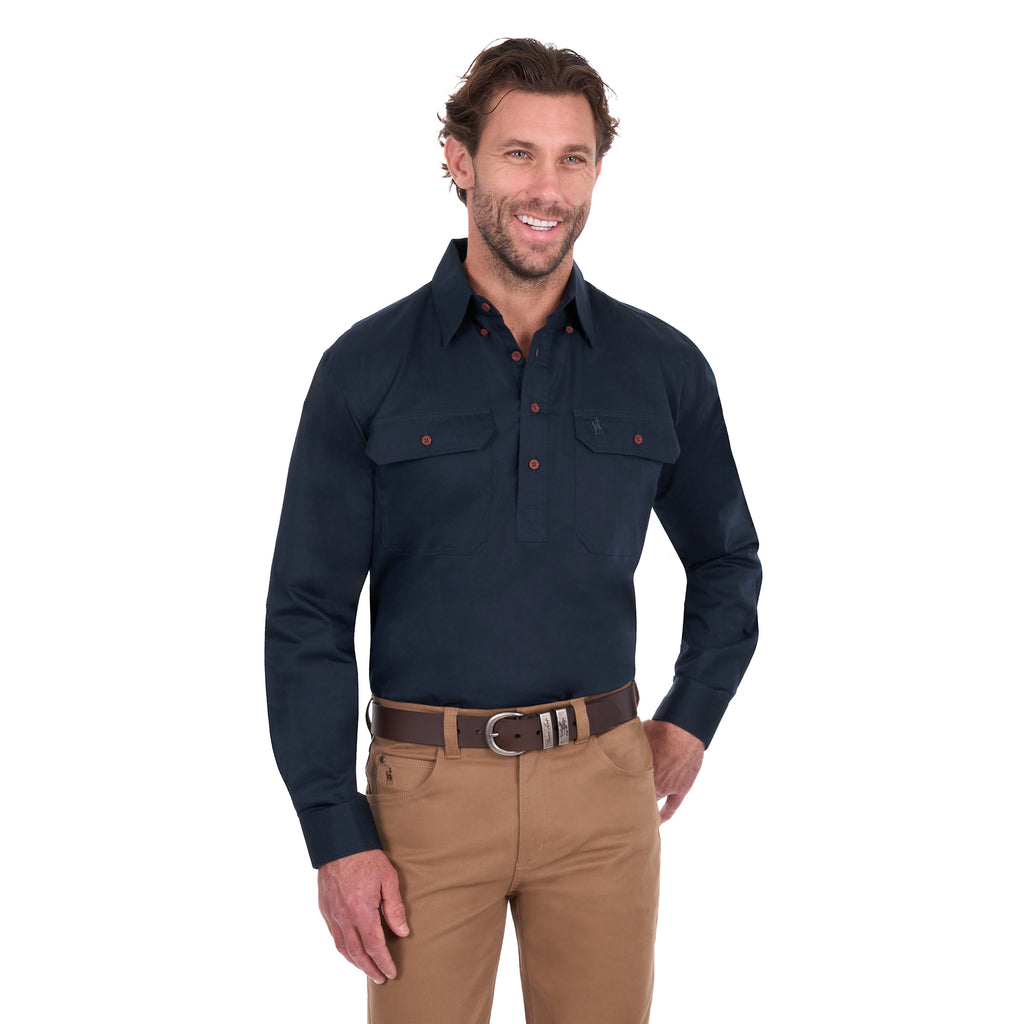 A man modelling a navy blue Thomas Cook Light Drill Half Button Long Sleeve Work Shirt (TCP1126005) with two chest flap pockets, paired with camel coloured jeans and a brown belt, against a plain white background.