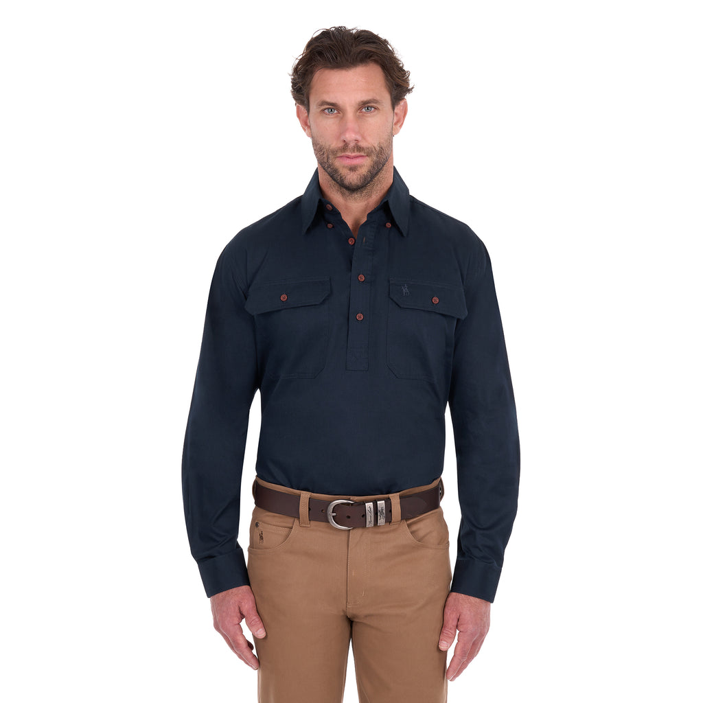 A man modelling a navy blue Thomas Cook Light Drill Half Button Long Sleeve Work Shirt (TCP1126005) with two chest flap pockets, paired with camel coloured jeans and a brown belt, against a plain white background.