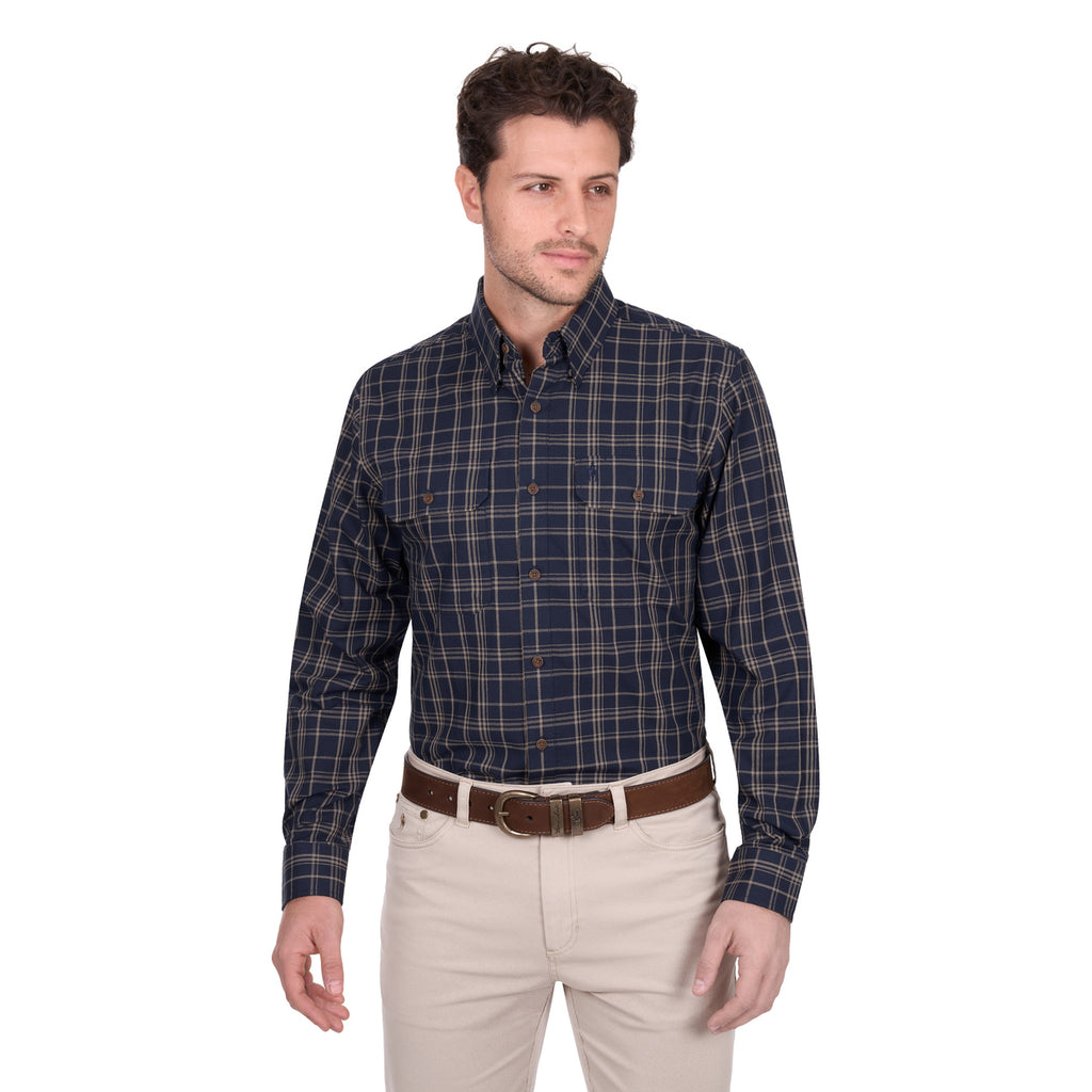 A man wears a Thomas Cook Mens Adam L/S Shirt (T6W1115034) in navy/tan, featuring cotton checks and a pen holder, tucked into light beige pants with a brown belt, standing against a plain white background.