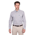 A man stands against a plain white background wearing a Thomas Cook Mens Chad L/S Shirt (T6W1115041) in navy/green, tucked into light beige pants with a belt.