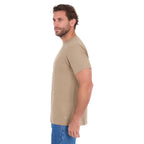 A man in profile modelling a sand Thomas Cook Men's Classic Fit Short Sleeve Tee (TCP1514051) paired with blue denim jeans on a white background.