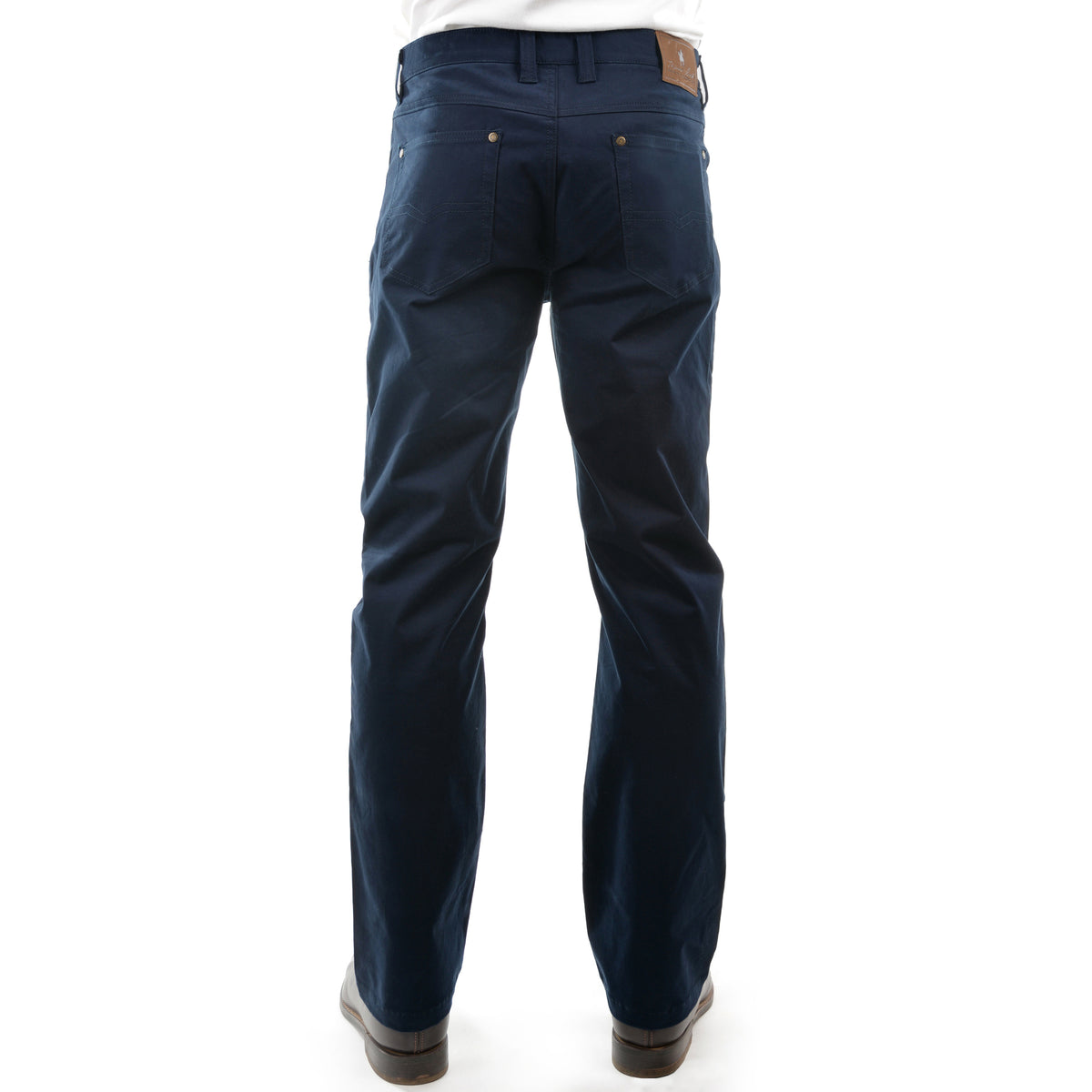A pair of dark navy Thomas Cook Men's Jake Comfort Waist Jeans (TCP1215031) viewed from behind on a model from the waist down, paired with a white shirt and dark brown leather boots, against a plain white background.
