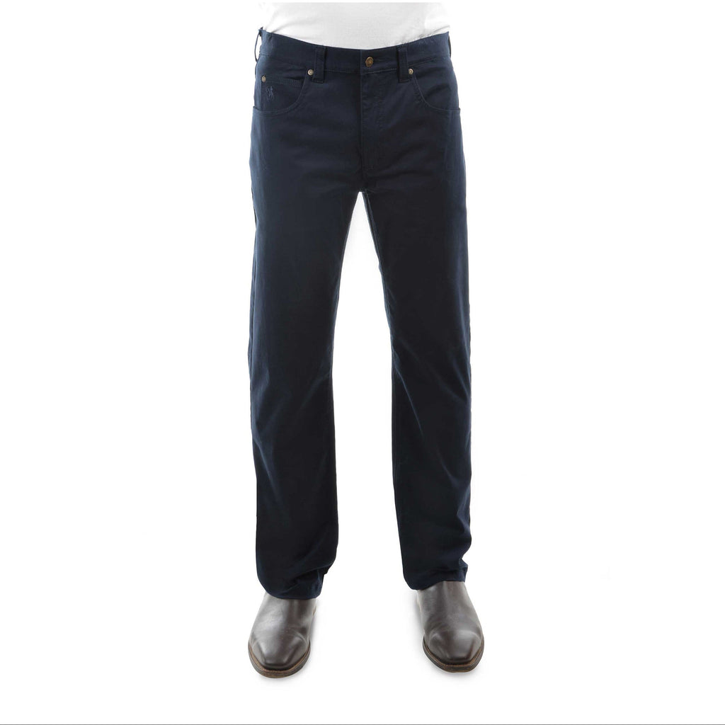 A pair of dark navy Thomas Cook Men's Jake Comfort Waist Jeans (TCP1215031) shown on a model from the waist down, paired with a white shirt and dark brown leather boots, against a plain white background.