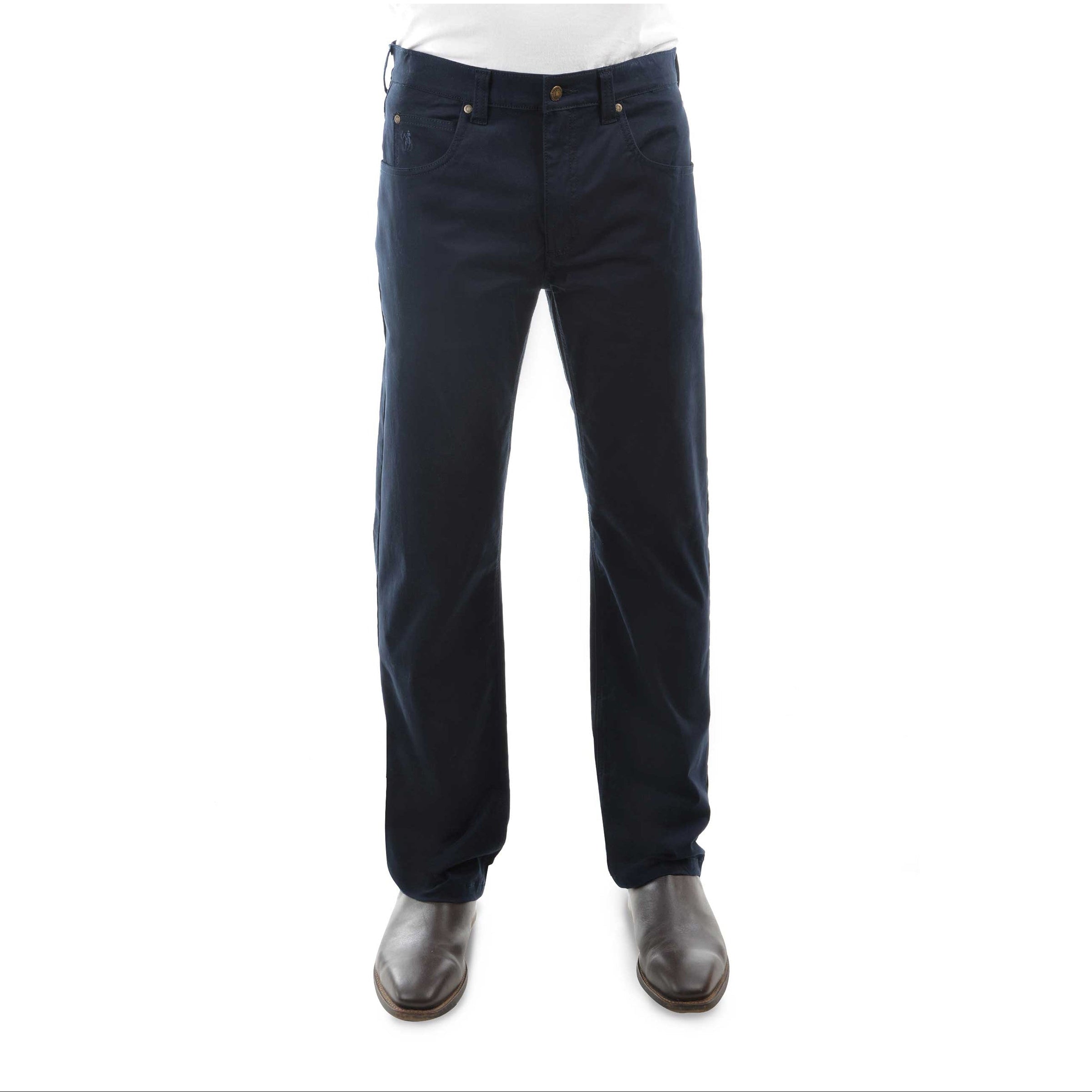 A pair of dark navy Thomas Cook Men's Jake Comfort Waist Jeans (TCP1215031) shown on a model from the waist down, paired with a white shirt and dark brown leather boots, against a plain white background.