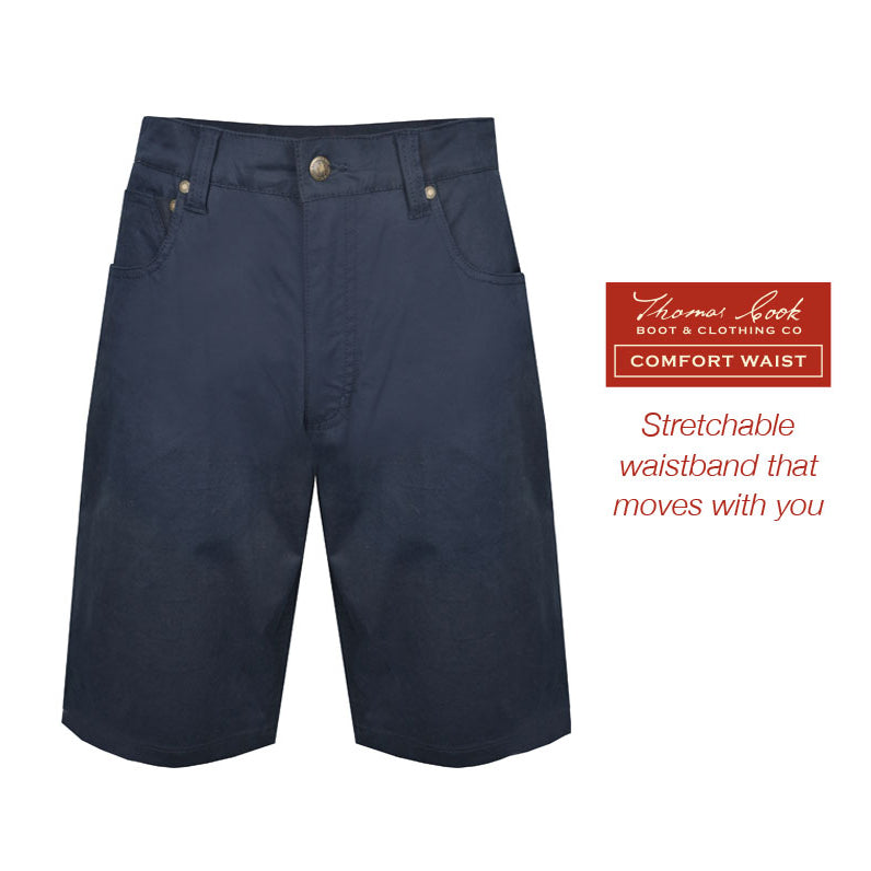 A pair of navy blue Thomas Cook Men's Jake Comfort Waist Shorts (TCP1307031) in flat lay with a branded label on the right side that reads 'Thomas Cook Boot & Clothing Co. Comfort Waist Stretchable waistband that moves with you'.
