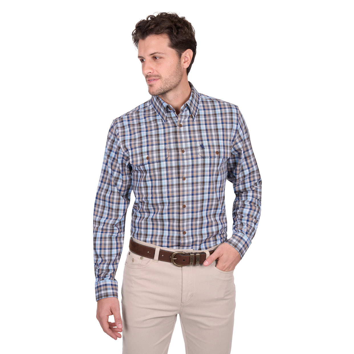 A man wears the Thomas Cook Mens Jonathan L/S Shirt (T6W1115039) Blue/Multi, featuring cotton check fabric and horseman embroidery, along with beige pants and a brown belt, standing against a white background looking to his left.