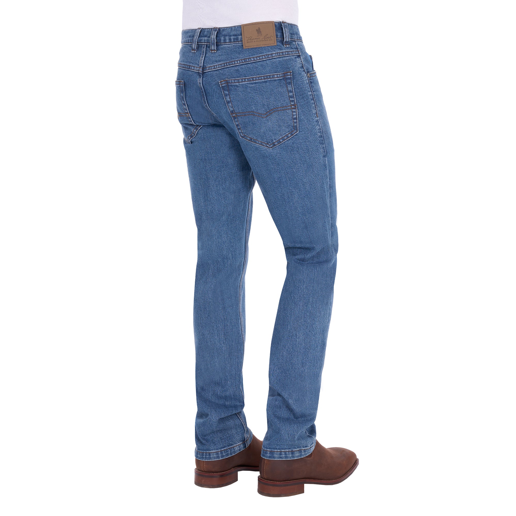 A man shown from the waist down, modelling a pair light blue Thomas Cook Men's Lochie Tailored Jeans (TCP1226064) paired with brown boots on a white background.