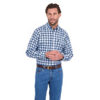 A man modelling a navy, blue and white Thomas Cook Men's Mitchell Long Sleeve Shirt (TCP1115100) paired with a brown belt and denim jeans on a white background.