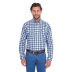 A man modelling a navy, blue and white Thomas Cook Men's Mitchell Long Sleeve Shirt (TCP1115100) paired with a brown belt and denim jeans on a white background.