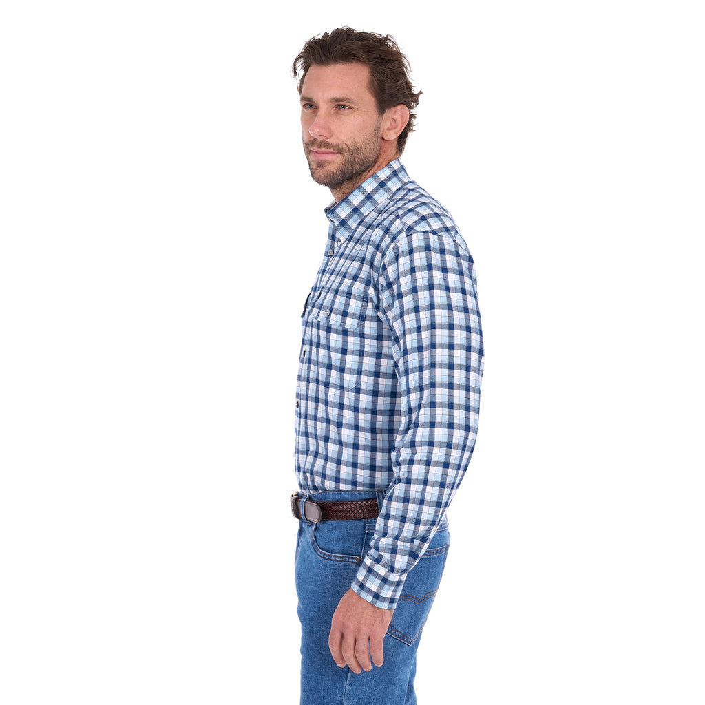 A man in profile modelling a navy, blue and white Thomas Cook Men's Mitchell Long Sleeve Shirt (TCP1115100) paired with a brown belt and denim jeans on a white background.