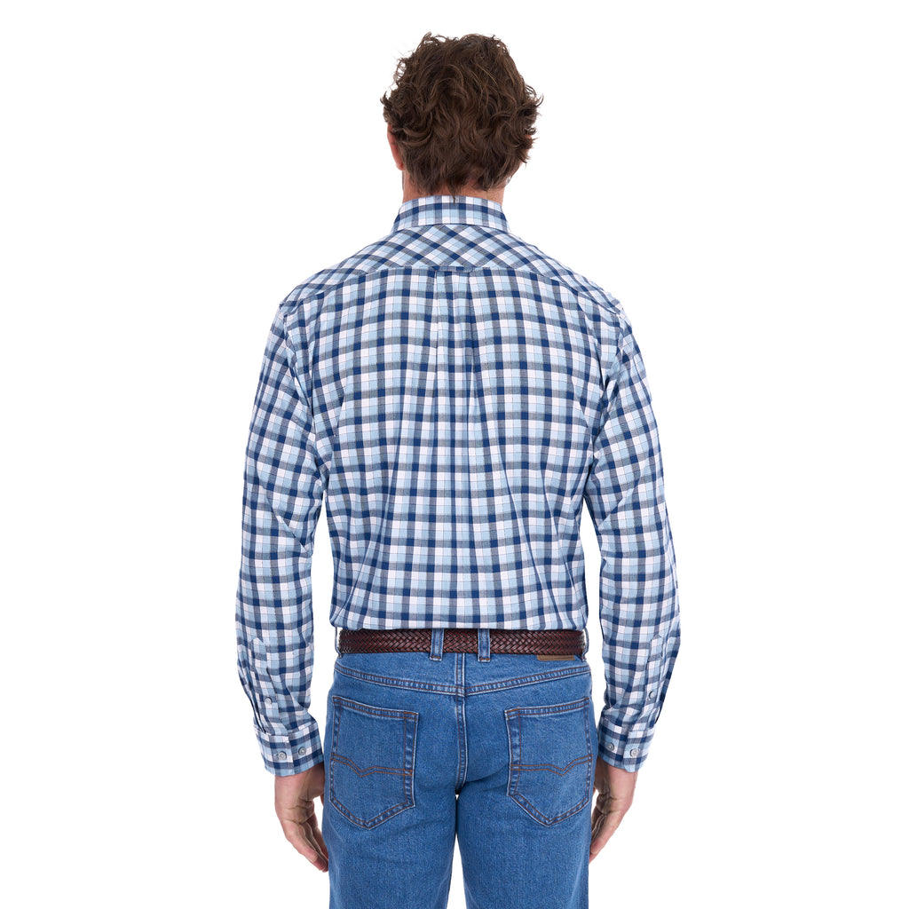 A man viewed from behind modelling a navy, blue and white Thomas Cook Men's Mitchell Long Sleeve Shirt (TCP1115100) paired with a brown belt and denim jeans on a white background.