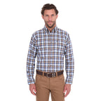 A man modelling a navy, tan, blue and white Thomas Cook Men's Mitchell Long Sleeve Shirt (TCP1115100) paired with a brown belt and camel coloured jeans on a white background.