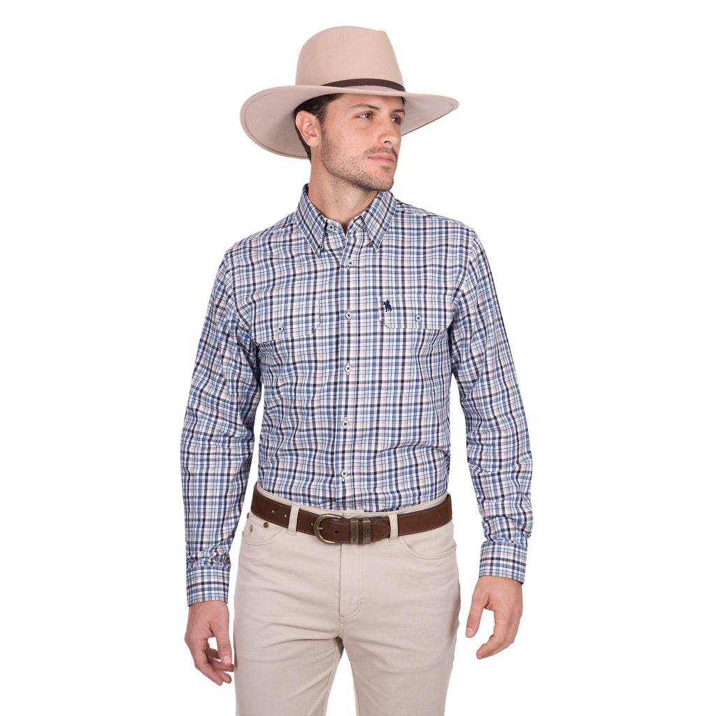 A man wearing the Thomas Cook Mens Patrick L/S Shirt (T6W1115035) Blue/Tan stands against a plain white background, paired with a light beige cowboy hat, brown belt, and beige pants, looking to his left.