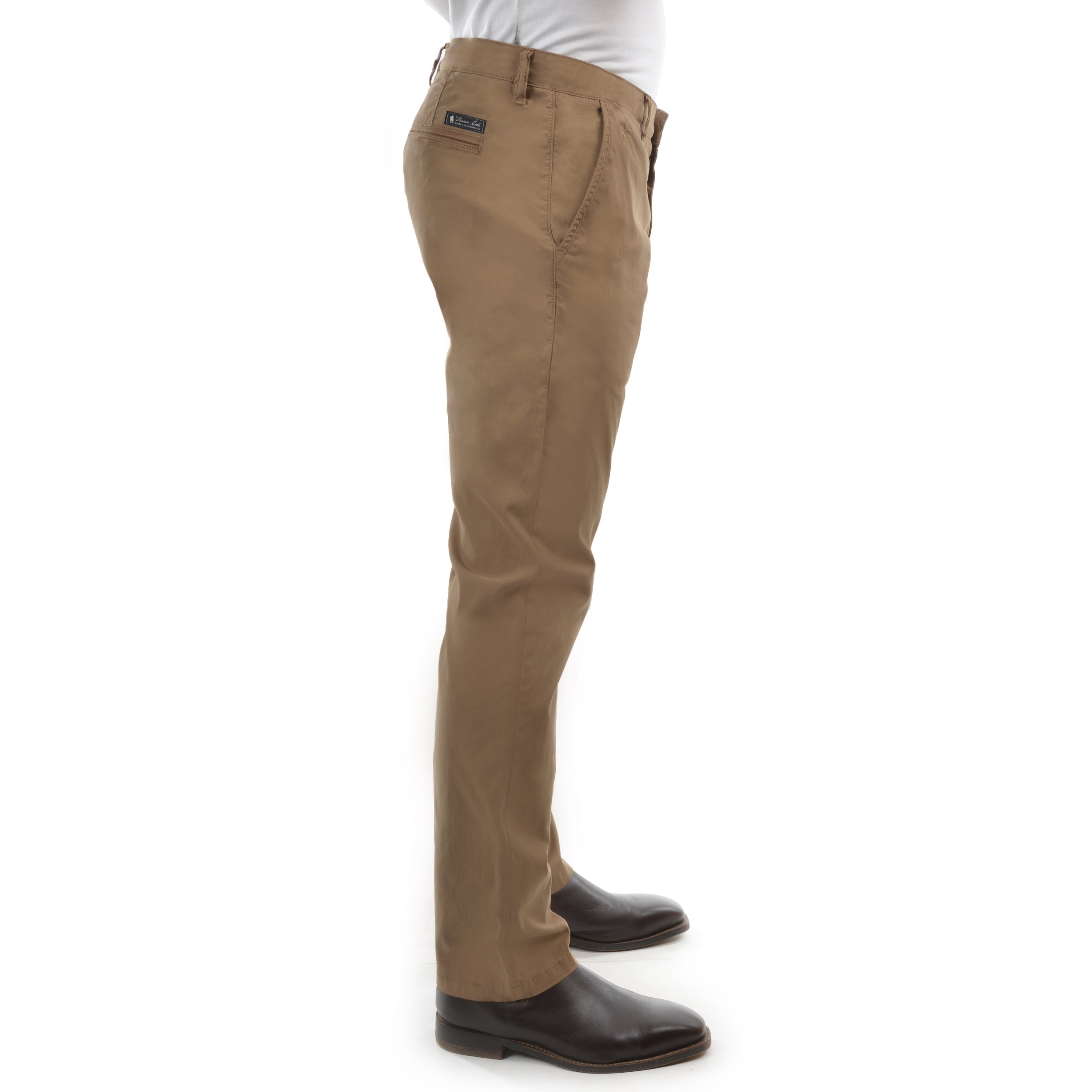 A man in profile from the waist down wearing a pair of camel Thomas Cook Men's Tailored Fit Mossman Comfort Waist Trousers (TCP1209091) with a pair of brown boots on a white studio background.