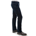 A man in profile, from the waist down wearing a pair of dark navy Thomas Cook Men's Tailored Fit Mossman Comfort Waist Trousers (TCP1209091) with a pair of brown boots on a white studio background.