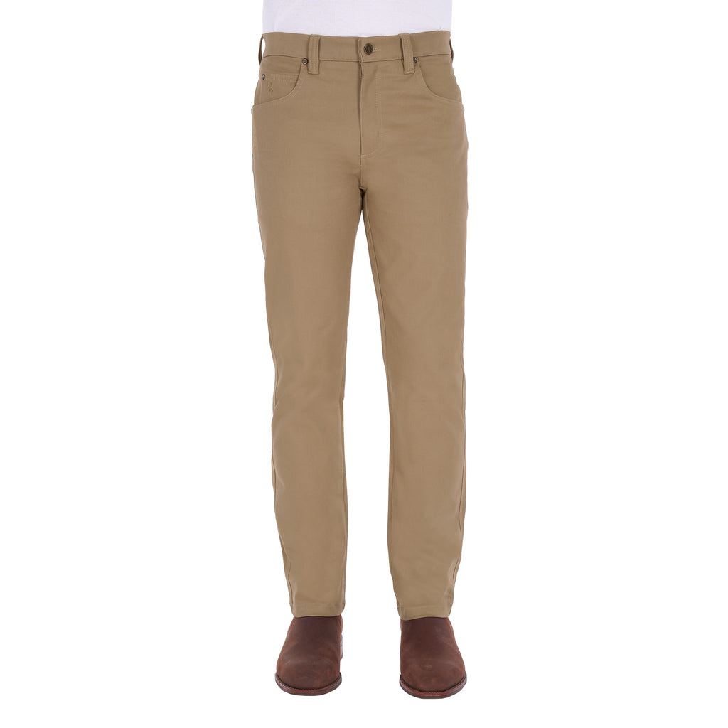 A man from the waist down modelling a pair of sand coloured Thomas Cook Men's Tailored Moleskin Jeans 30" Leg (TCP1206007) paired with a white tee and brown boots.