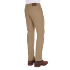 A man viewed from 3-4 back from the waist down modelling a pair of sand coloured Thomas Cook Men's Tailored Moleskin Jeans 30" Leg (TCP1206007) paired with a white tee and brown boots.