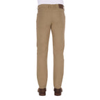 A man viewed from behind from the waist down modelling a pair of sand coloured Thomas Cook Men's Tailored Moleskin Jeans 30" Leg (TCP1206007) paired with a white tee and brown boots.